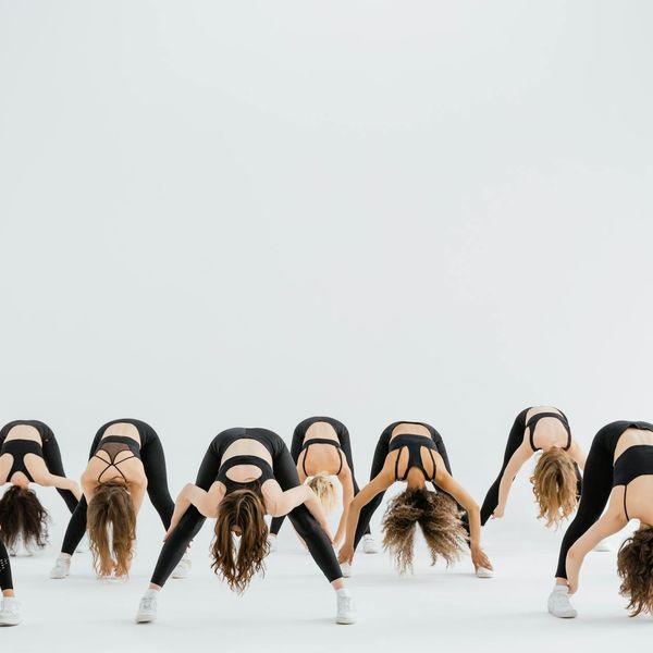 A person in the middle of a dynamic stretching movement.